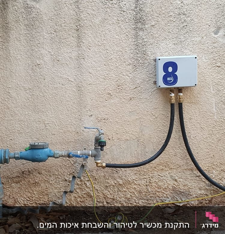 צנרת מים עם ברזים וקופסת חיבורים על קיר